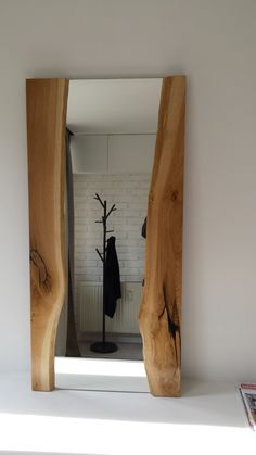 a mirror that is on top of a shelf next to a coat rack and hat rack