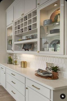 a kitchen with white cabinets and gold accents on the countertop, along with an oven