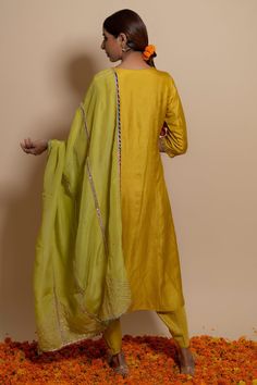 Yellow silk embroidered yoke A-line kurta. Paired with tulip pants. Comes with organza gota embroidered dupatta.
Component: 3
Pattern: Embroidered
Type Of Work: Gota,pearl,zardozi 
Neckline: Round
Sleeve Type: Three quarter
Fabric: Silk, bamber satin, organza
Color: Yellow,Green
Other Details: 
Multicolour lace on dupatta
Shell and lace tassel
Gota lined dupatta
Occasion: Mehendi and Haldi,Sangeet - Aza Fashions Lace On Dupatta, Lace Tassel, Tulip Pants, Kurta Set For Women, A Line Kurta, Yellow Silk, Embroidered Dupatta, Fabric Silk, Kurta Set