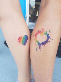 two people with tattoos on their legs and one has a heart painted on the leg