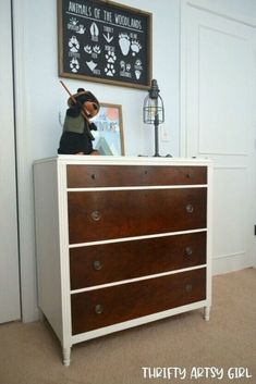 a teddy bear sitting on top of a dresser in a room with white walls and brown carpet