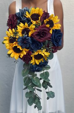 a bride holding a bouquet of sunflowers and roses