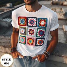 a man wearing a white t - shirt with colorful crochet squares on it