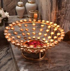 a table with candles and vases sitting on it's side, in front of a marble wall