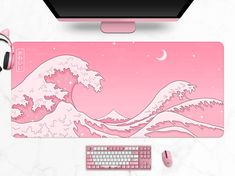 a pink mouse pad sitting on top of a desk next to a keyboard and headphones