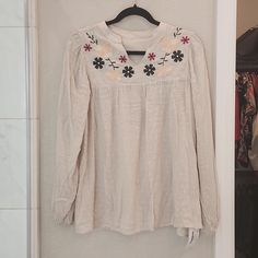 This Is A Brand New Tanish/Cream Top. Never Worn. Flowers Are Embroidered. Long Flowy Sleeves. Can Be Dressy Or Casual. Size Small Beige Feminine Tops With Floral Embroidery, Spring Off-white Tops With Floral Embroidery, Feminine Embroidered Beige Tops, Spring Off White Tops With Floral Embroidery, Cream Embroidered Spring Tops, Cream Embroidered Top For Spring, Off White Tops With Floral Embroidery For Spring, Casual Embroidered Cream Blouse, Cream V-neck Top With Floral Embroidery