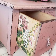 an old pink dresser with flowers painted on it