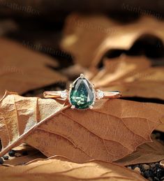 a green ring sitting on top of a leaf