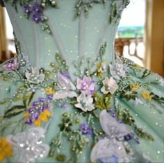 the back of a dress with flowers painted on it's sides and sequins