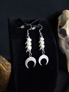 Here are Some Lovely Small Crescent Moon Earrings! Each Pair Has 6 Real Rattlesnake Vertebrae,  And 2 Stainless Steel Moon Charms! The Hooks are Also Stainless Steel. They Are Right About 2-1/2 Inches long. All Items Ship Within 1-3 Days via USPS First Class Service, With Some Upgrades Available Also. Shipping on These Earrings Will be 5.00 Additional Items are Free! International Shipping Will Be 20.00, And All Additional Items Are FREE! International Shipping May Take 2 - 6 Weeks To Deliver. I Always Love to Accommodate Custom Orders! If you Have Something in Mind , Please Message me. Have a Drawing or a Photo of Your Inspiration and Send it to Me! And Also Please Send Me Your Preferred Budget For Your Piece, To Make Sure You are Not Overcharged. I DO NOT Carry Human Bones or Any Sort Of Bone Color Dangle Earrings With Ear Wire, Nickel-free Bone Dangle Earrings, Nickel Free Bone Color Dangle Earrings, Nickel-free Bone-colored Dangle Earrings, Bone Colored Metal Earrings For Pierced Ears, Bone Colored Earrings With Ear Wire For Gift, Handmade Metal Jewelry In Bone Color, Handmade Adjustable Bone Colored Earrings, Wiccan Earrings