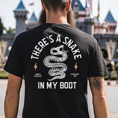 Howdy partners! Channel your inner Woody with this rockin' "There's a Snake in My Boot" t-shirt. The front features Woody's iconic catchphrase straight from Toy Story, while the back shows a slick snake design with lightning bolts for an edgy, rock n' roll vibe. Disney Vinyl Shirts Men, Frozen Mens Shirt, Cute Couple Disney Shirts Peter Pan, Men Disney Shirts Vinyl, Mens Disneyland Shirts, Mens Vintage Disney Shirt, Christmas Disney Shirts Boys, Adult Disney Shirts Toy Story, Disney Christmas Shirts Toy Story