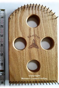 a wooden object with holes in it next to a ruler