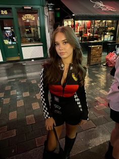 a woman in black and red outfit holding an umbrella