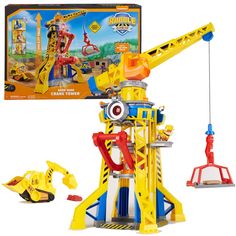 a yellow and blue toy crane next to a box with other toys in it on a white background