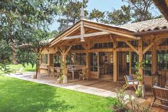 a large wooden house sitting on top of a lush green field