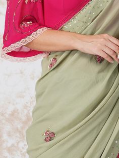 Semi Sheer georgette saree embroidered with pink beads butas and detailed with a contrasting lace. It comes with an unstitched, hotpink georgette blouse piece with beadwork. Color: Sage Green Fabric: Gerogette Note: Wash Care - Dry Clean only The product will be delivered within 3-4 weeks of order placed Relaxed Fit Cutdana Work, Zardozi Work, Floral Saree, Sequins Fabric, Embroidered Saree, Georgette Blouse, Green Saree, Contrast Blouse, Georgette Saree