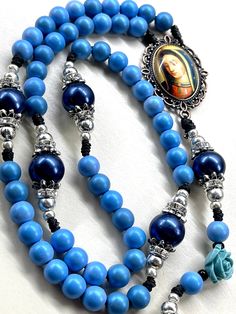 Handmade Rosary with Bronze Lady of Guadalupe centerpiece beautiful blue wooden beads and large blue Pearl Pater beads includes Indulgence bronze crucifix Catholic gift Communion gift  Catholic mom gift God parent gift These rosaries are beautiful and would make a wonderful First Communion/Reconciliation or Confirmation gift, wedding gift, or RCIA PSR gift.  The colors are vibrant and gorgeous!   The bronze Indulgence pardon  crucifix is Made in Italy  Bronze Lady of Guadalupe centerpiece is col Blue Crucifix Necklace For Spiritual Wear, Blue Crucifix Necklace For Spiritual Purposes, Blue Rosary With 8mm Beads And Crucifix, Blue Rosary With 8mm Beads In Cross Shape, Blue Necklaces With Wooden Beads, Spiritual Blue Necklace With Wooden Beads, Blue Spiritual Necklace With Wooden Beads, Blue 108 Beads Spiritual Rosary, Spiritual Blue Rosary With 108 Beads