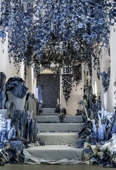 a room filled with lots of blue and white furniture covered in cloths on top of each other