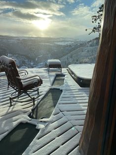 a chair sitting on top of a snow covered roof next to a hot tub under a cloudy sky