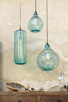 three blue glass pendant lights hanging from a ceiling