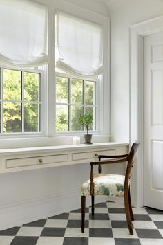 a chair sitting in front of a window next to a checkered floor