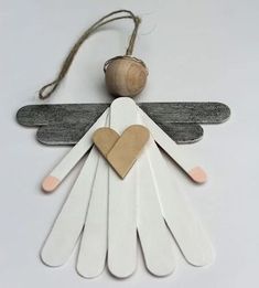 an angel ornament made out of popsicle sticks with a heart on it