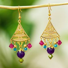 This delicate set of filigree earrings is handcrafted in 14k gold-plated steel and finished with a pair of deep purple agate beads surrounded by colorful faceted Swarovski crystals. Alejandra Aceves is an award-winning jewelry maker from Tamaulipas Mexico. She studied jewelry-making in Italy and Brazil and her designs have won multiple international competitions. Award Winning Jewelry, Purple Agate, Filigree Earrings, Handmade Beaded Jewelry, Jewelry Maker, Agate Beads, Green And Blue, Hook Earrings, Chandelier Earrings