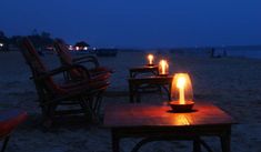 lit candles are sitting on tables at the beach