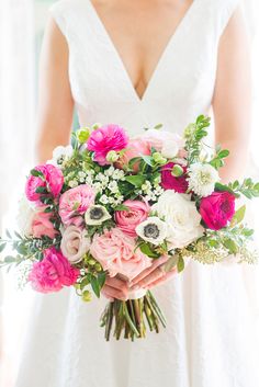 a bride holding a bouquet of pink and white flowers