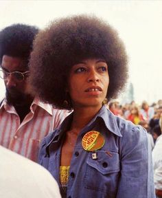 a woman with an afro standing in front of a crowd