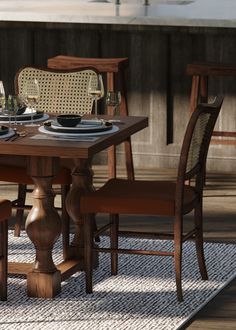 a wooden table with chairs and plates on it in the middle of a floored area