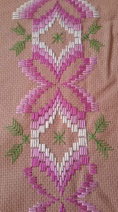 a close up of a pink and white design on a fabric material that has been stitched together