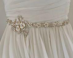 "Unique and romantic.  This enamel floral bridal wedding sash is accented with tons of sparkling crystals. This Delicate wedding belt beautifully compliments  your Boho, rustic or woodland wedding look.  READY TO SHIP  DETAILS * Design measures aprox. 2.25' wide (at widest part by 14\" long. * Offered in silve Metal or or Gold Metal *  Attached at ends to imported French satin ribbon in choice of colors View my complete collection including Bridal Sashes, Bridal Headpieces, Fascinators, Cuff Bra Elegant Bridal Belt With Flower Decoration For Wedding, Elegant White Sash For Mother Of The Bride, Elegant White Sashes For Mother Of The Bride, Elegant Bridal Belt With Flower Decoration, White Bridal Sash Belt For Bridesmaid, White Bridal Belt With Sashes For Bridesmaid, Cream Bridal Belt With Sashes For Wedding, White Bridal Accessories With Sashes, White Embroidered Bridal Belt For Wedding