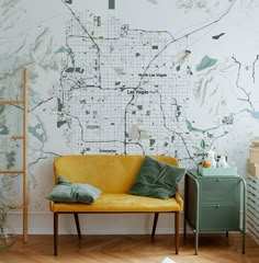 a yellow couch sitting in front of a wall with a map on it's side