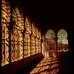 the sun shines through stained glass windows in an old building with arches and arched doorways