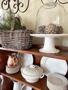 a shelf filled with dishes and plates under a glass dome