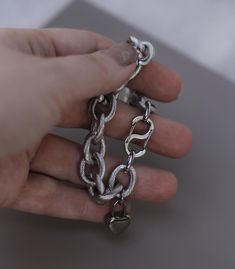 Made from high-quality steel fittings, this chain is very durable and heavy. Each link of the chain has a texture that adds to the longevity of the jewelry. The bracelet features a two-sided, easy-to-use S-shaped clasp and includes a heart-shaped lock charm. The total length of the bracelet is 8 1/4 inches. I can shorten it by removing links; please contact me in advance for adjustments Metal Chain Bracelet With Rectangular Links, Minimalist Metal Chain Bracelet With Oval Links, Chunky Stainless Steel Bracelet With Rectangular Links, Metal Link Chain Charm Bracelet, Metal Cable Chain Link Bracelets, Metal Charm Bracelet With Rectangular Links, Silver Metal Link Chain Bracelet, Minimalist Sterling Silver Bracelet With Solid Link, Modern Metal Chain Link Bracelet