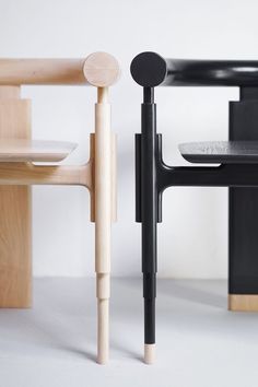 two black and white chairs sitting next to each other on top of a white floor