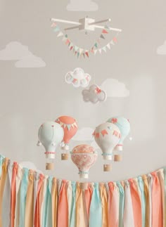 a baby's room with hot air balloons hanging from the ceiling and decorations on the wall