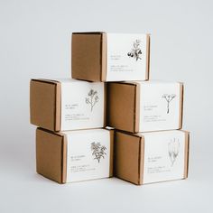 four boxes with different types of flowers on them sitting next to each other in front of a white background