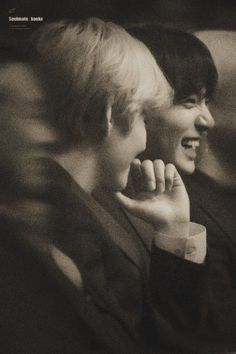 two people sitting next to each other smiling