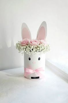 an easter bunny planter with pink roses and baby's breath flowers in it