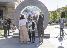 some people are standing in front of a large circle with pictures on it and one person is pointing at something