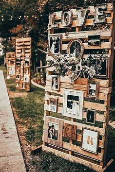 a wooden sign with pictures on it sitting in the grass