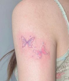 a woman with a tattoo on her arm has a pink and blue butterfly on it