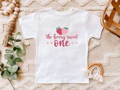 Introducing our super cute strawberry theme birthday t-shirts, for a boy or girls' berry sweet theme party. These shirts are high quality and made with 100% soft ringspun cotton for very comfortable wear.   HOW TO ORDER 1. Select the color and size/name from the drop-down menu and add it to the cart 2. Repeat the process if you want to order more shirts 3. If you want a custom shirt, please select that from the menu and add the name to the personalization box NB: We have multiple options for Mom Sweet Pink T-shirt For Birthday, Sweet Letter Print T-shirt For Birthday, Sweet T-shirt For Summer Birthday, Sweet Summer Birthday T-shirt, Sweet Cotton T-shirt For First Birthday, Sweet White T-shirt For First Birthday, Cute Strawberry Print Top For Birthday, Casual Birthday T-shirt With Strawberry Print, Strawberry Theme Birthday