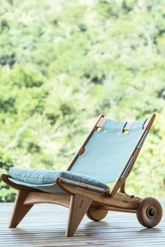 a wooden chair with a blue cushion sitting on it's back and wheels attached to the seat