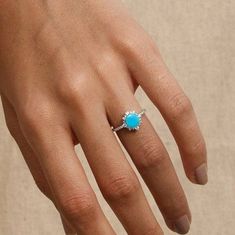 a woman's hand with a turquoise ring on it