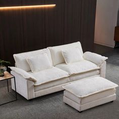 a white couch and ottoman in a room