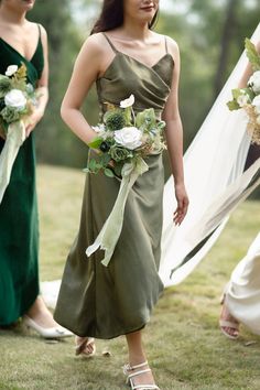 the bridesmaids are dressed in green dresses and holding bouquets with white flowers